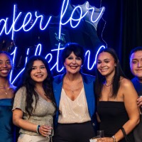 President Mantella takes a picture with a boy and 4 girls on the stage.